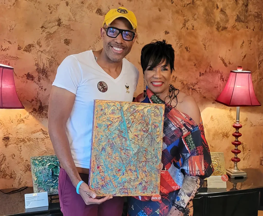 Kim with a happy customer posing with his new one of a kind piece of artwork
